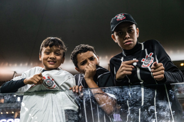 Jovens torcedores apontando e beijando o escudo do Corinthians na Neo Qu�mica Arena