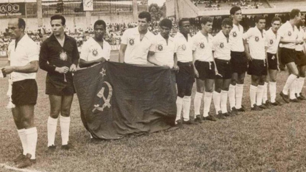 Foto da equipe que disputou a partida com a bandeira da