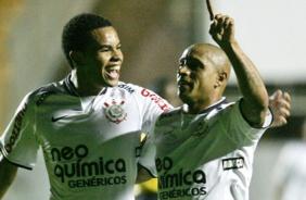 Dentinho comemorando gol ao lado de Roberto Carlos