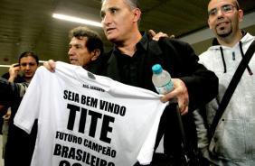 Tite recebe uma camisa de um torcedor no desembarque em Guarulhos