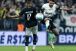 Raniele saltando para chutar a bola em dividida com jogador do Botafogo